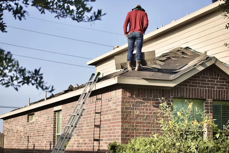 Professional roofer working on a residential roof in Centerton